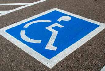 An accessible parking sign painted in a parking spot