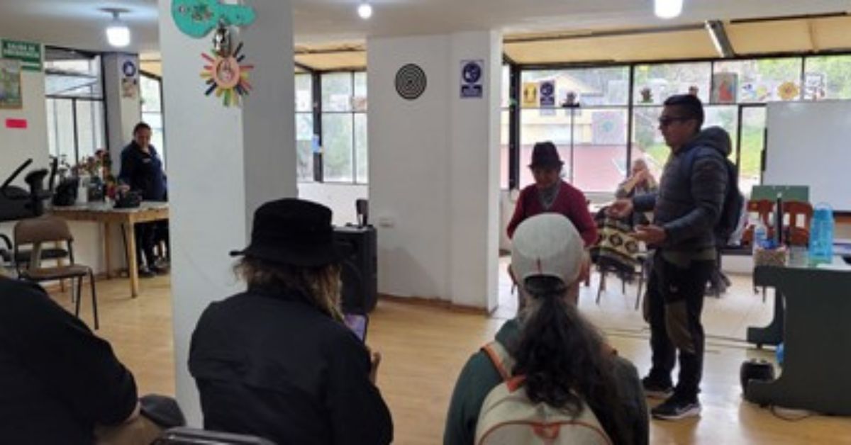 A group of people meeting elders and leaders in a studio with art hanging on the walls.