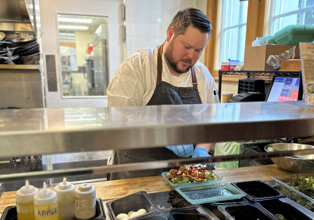 The chef at Royal Roads University's Habitat Cafe prepares a salad behind a food counter