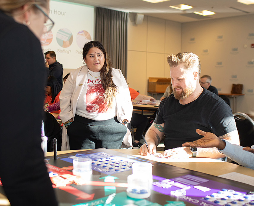 RRU students sit at a table working through a group activity in a busy room.