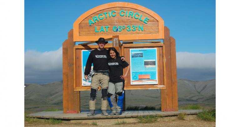 Brian Mendoza Dominguez and friend pose in front of the sign at the Arctic Circle