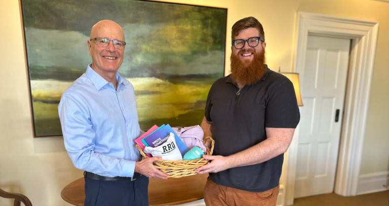 President Steenkamp presents student Trevor Williams with his poetry prize pack.