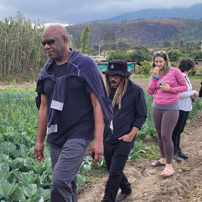 A group of people walking through a vegetable field during an outdoor learning or community project.