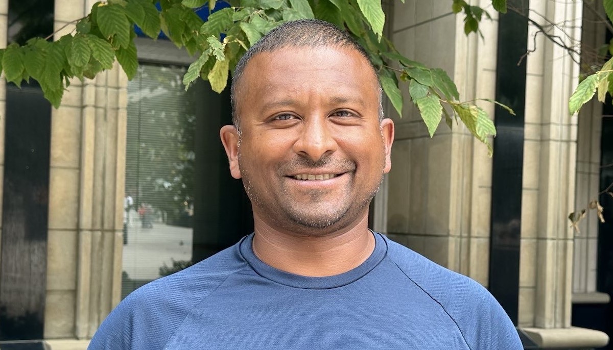 Man in blue shirt looking at camera and smiling.