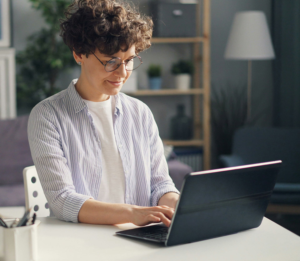RRU student sits at their home office typing on a laptop