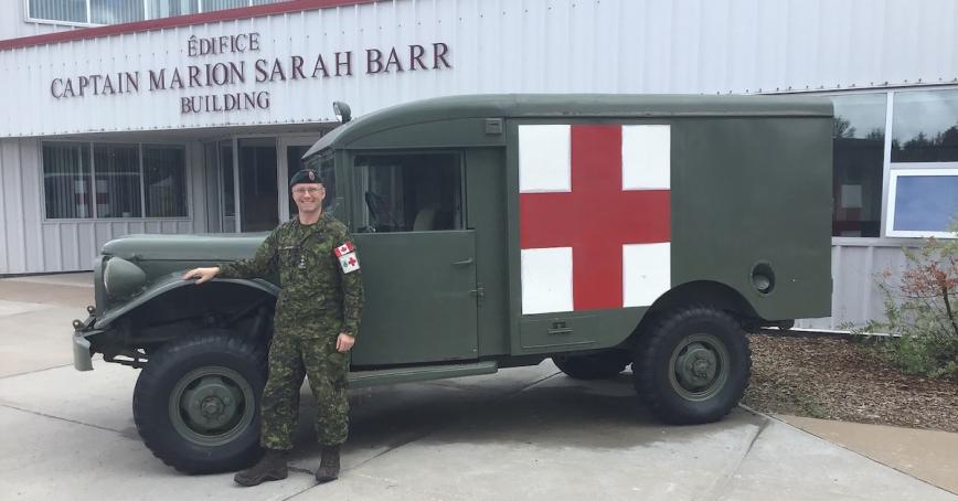 Alum Captain Mike Gauthier standing by a military medical vehicle.
