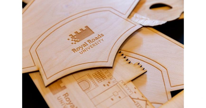 Wooden cut-out of RRU graduation cap and Hatley Castle