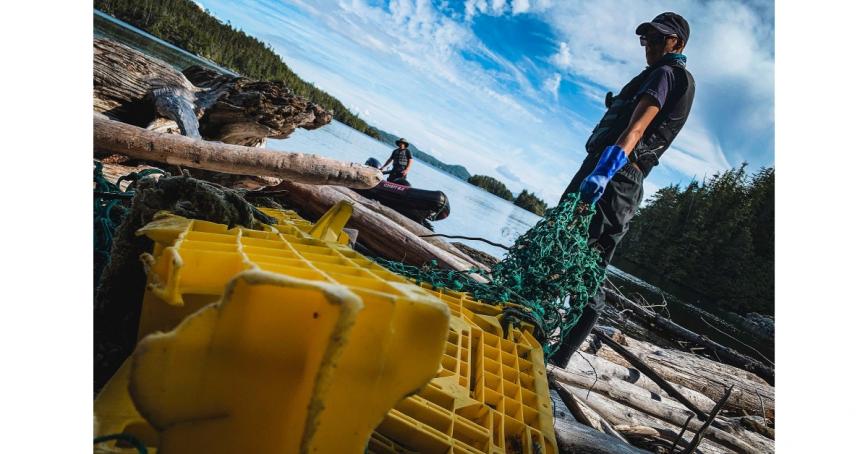 person-holding-net-next-to-plastic-crates-on-beach