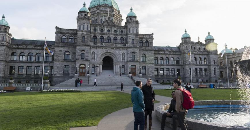 Group of students standing next to a fountain in front of the BC Legislature building.