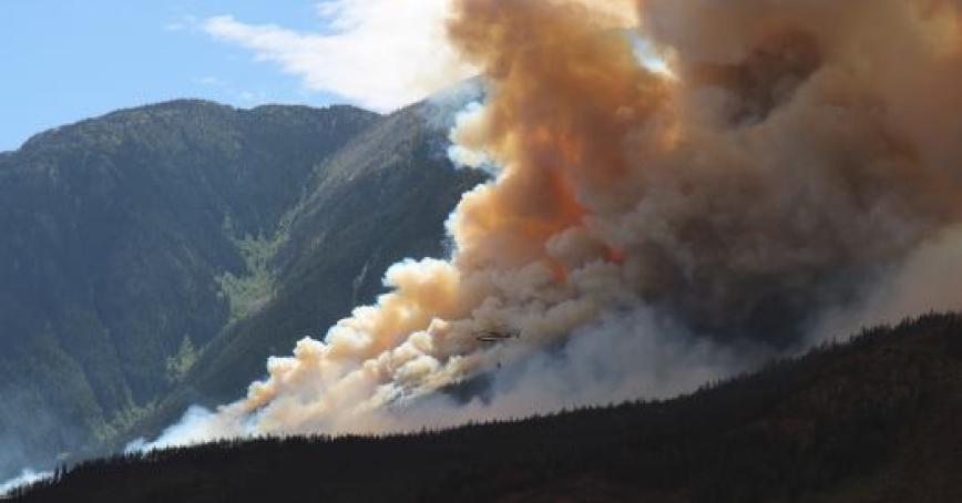 Fire and smoke seen on a mountain side.