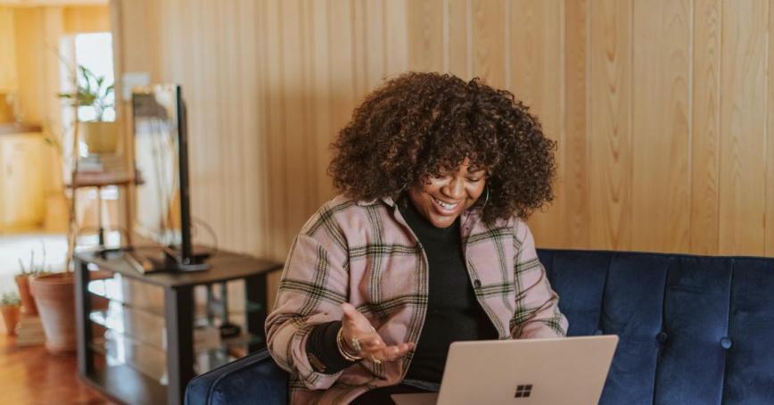 A female smiling and looking at her laptop