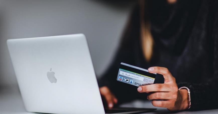 An image of someone using a laptop while holding a credit card