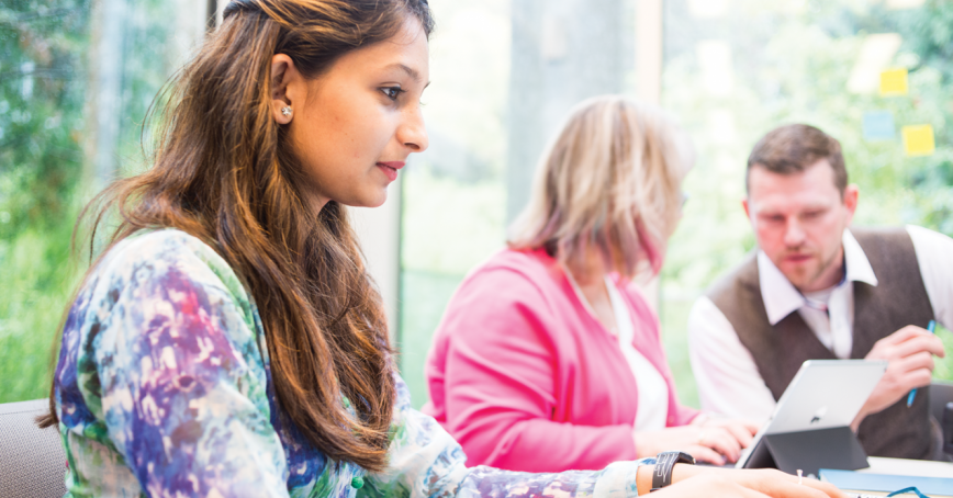 Three people sitting at a table talking
