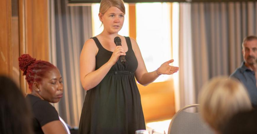 Image of a woman talking with a mic in hand