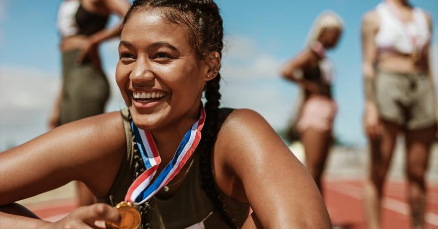 Person sitting with sport medal around neck