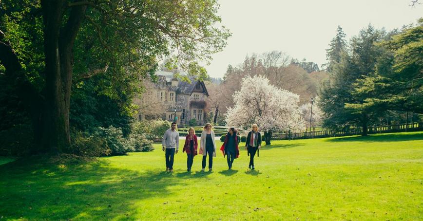 people walking on grass at Royal Roads University