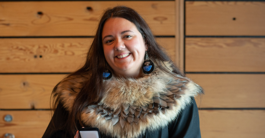 Katelynne Herchak dressed in her grad gown with fur trim, holding her Liertenant Govenor's Medal