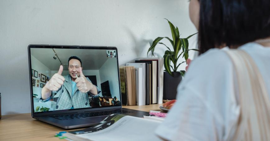 Person looking at someone else on a laptop