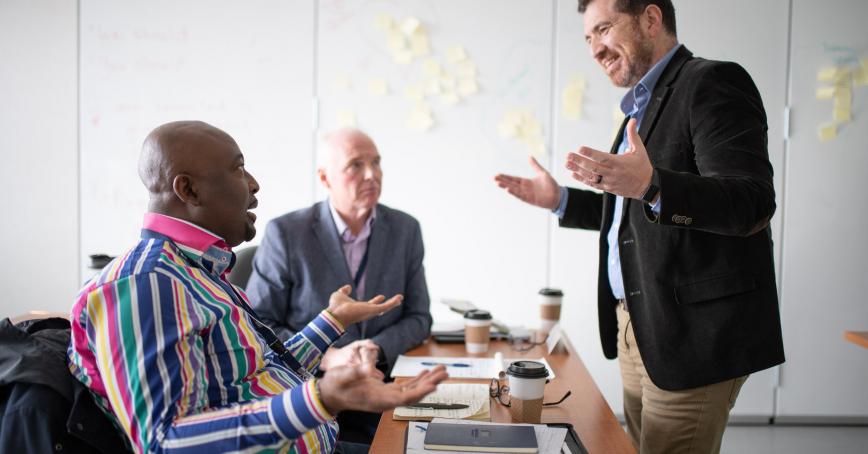 Three people sitting at a table talking