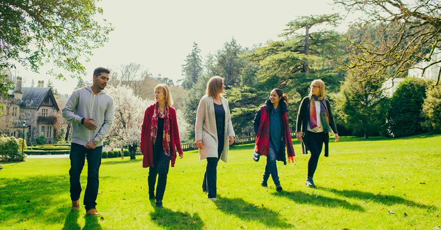 A group of people walking on a lawn.