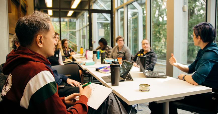 Students working at a long table in RRU's library.