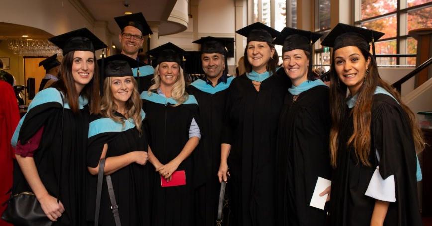 Smiling people wearing Convocation regalia at the 2019 Convocation held at the Royal Theatre in Victoria.