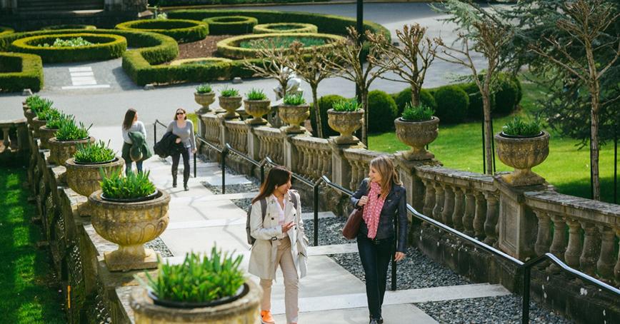 Students walking up an outdoor staircase in front of Hatley Castle at Royal Roads University