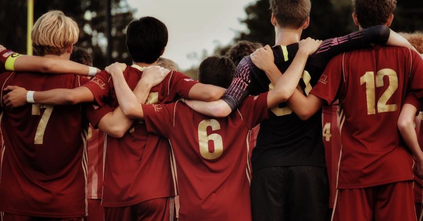 group of people huddled together before a sports game