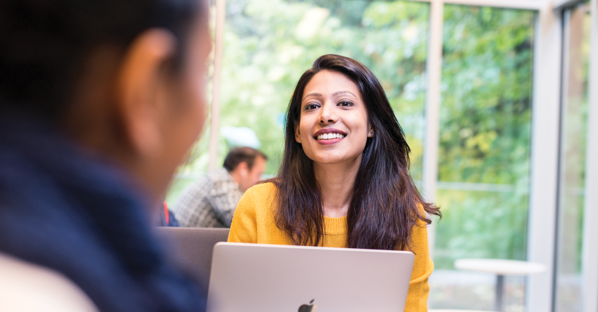 student smiling with their laptop