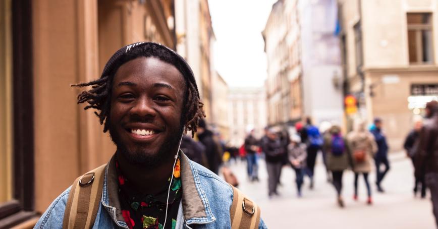 a happy student walking in a busy street