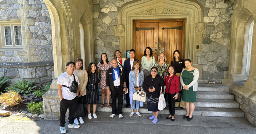 Group of Phillipine delegates and RRU staff standing on a set of stairs in front of Hatley Castle's door.
