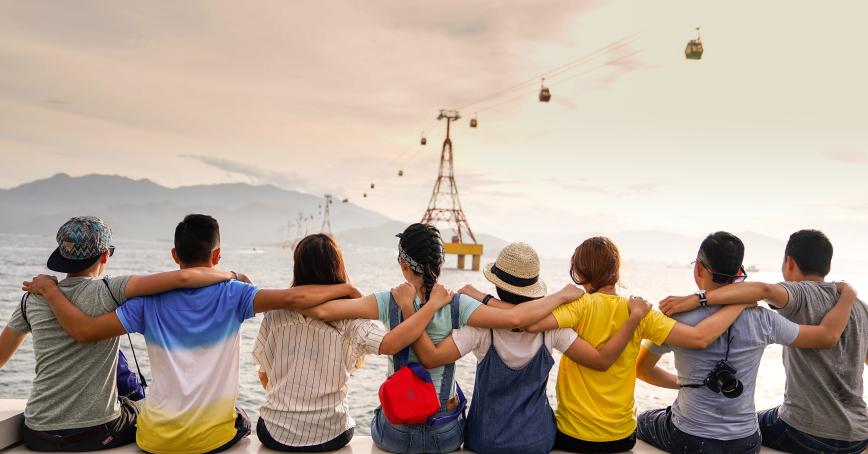 people holding each each other, outside, looking at a tourist attraction