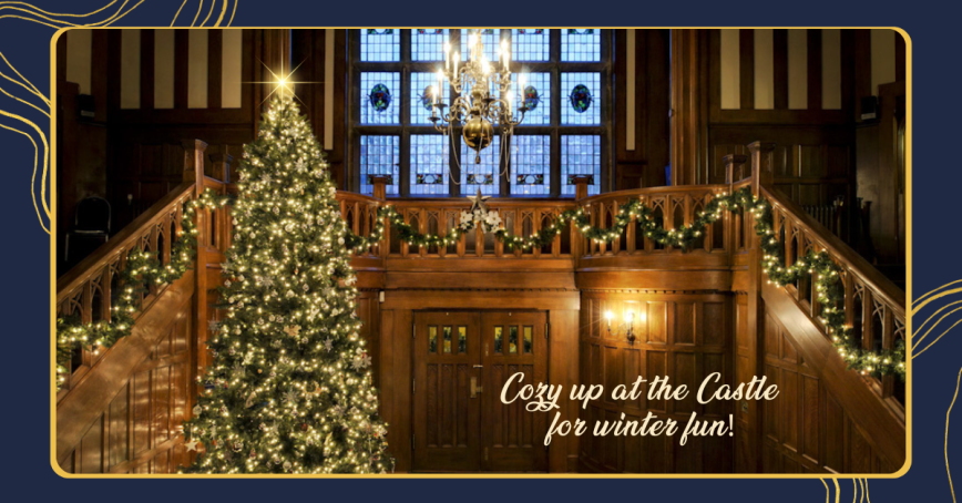 The entrance to Hatley Castle aglow with a tree, candles and chandelier.