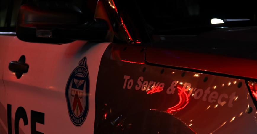 a police car saying to serve and protect.