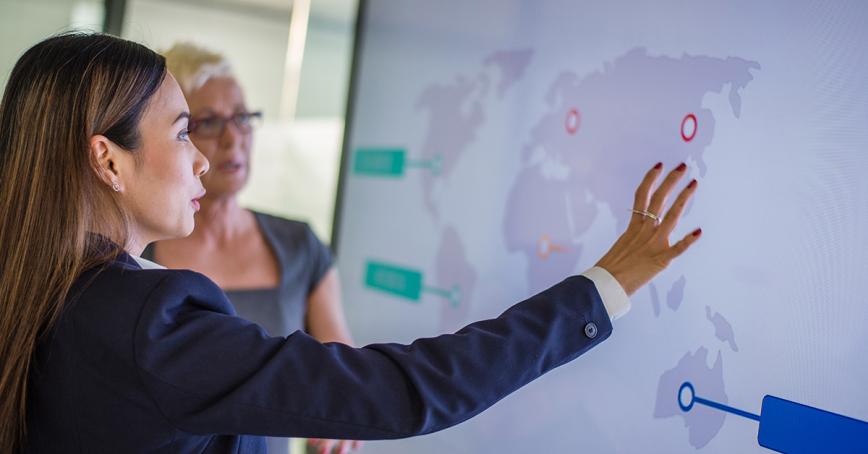 Students studying map of world projected on screen