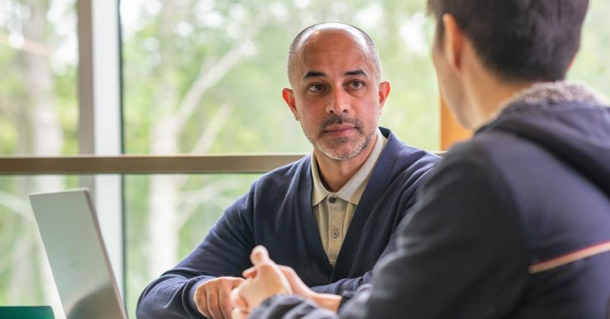 Two people speaking in front of a laptop 