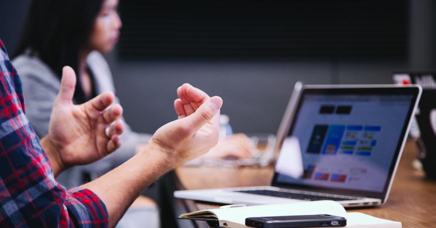 Hands gesturing to computer