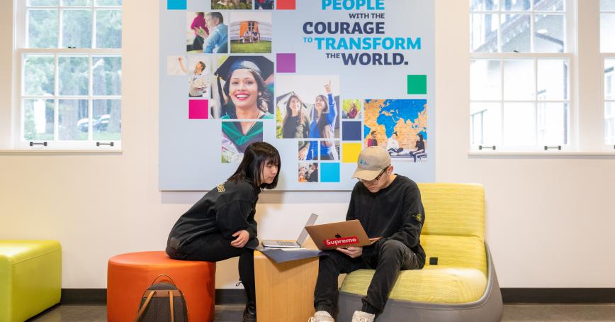 students looking at laptop on campus