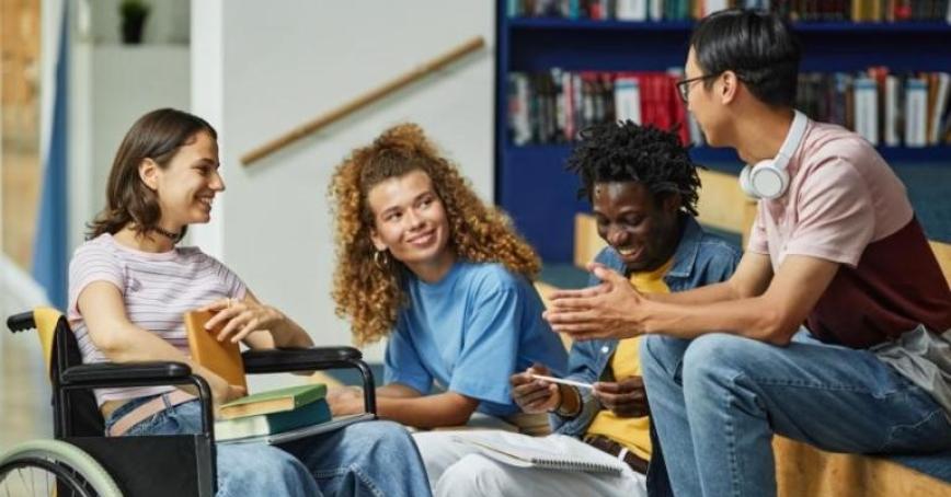 A group of four people sit together. They look happy.