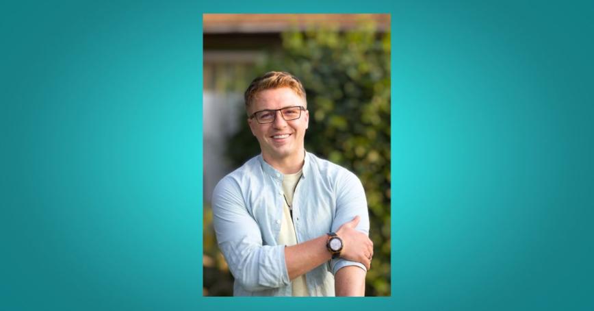 Liam Moise smiling with a tree behind him.