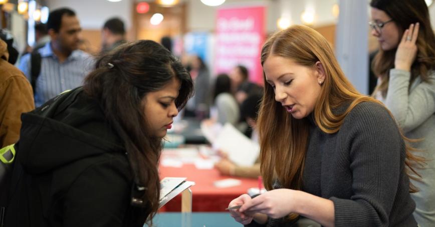 Two women chatting at a trade fair.