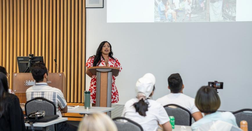 Speaker at a podium speaking to a classroom of students