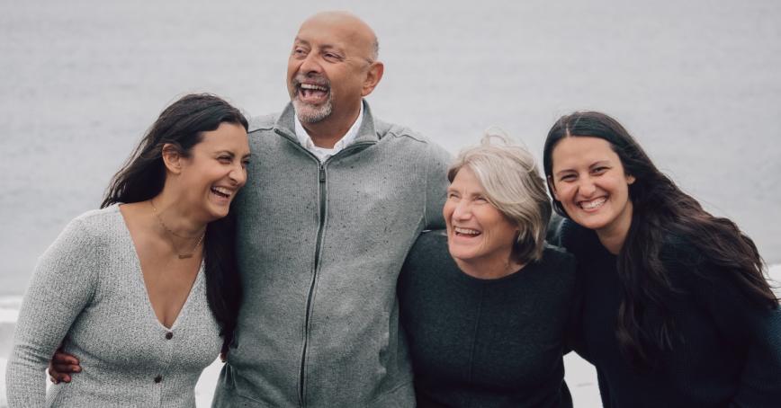 Brar family posed with their arms around each other, laughing with joy.