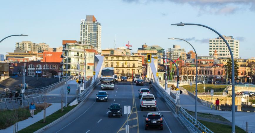 View of Johnson St. bridge with traffic and downtown Victoria buildings