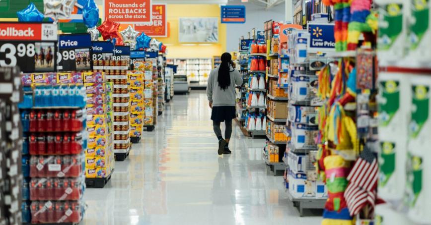 Person walking down store aisle featuring household goods.