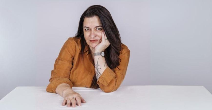Kevina Power sits at a white table with her chin on her hand