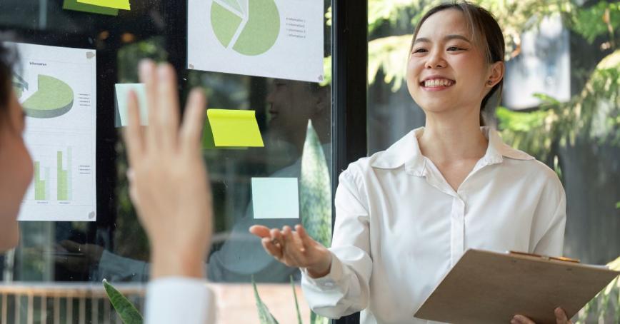 Two students in a natural office environment discussing charts