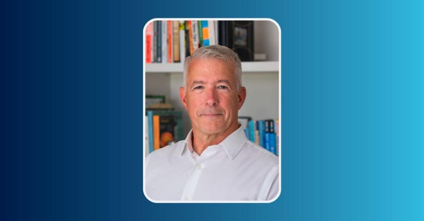 Curtis Clarke smiling in front of a book shelf