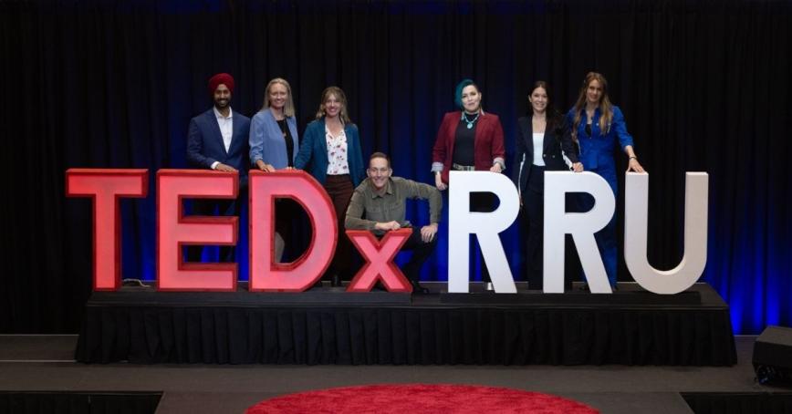 TEDxRRU 2025 speakers pose behind the TEDXRRU sign