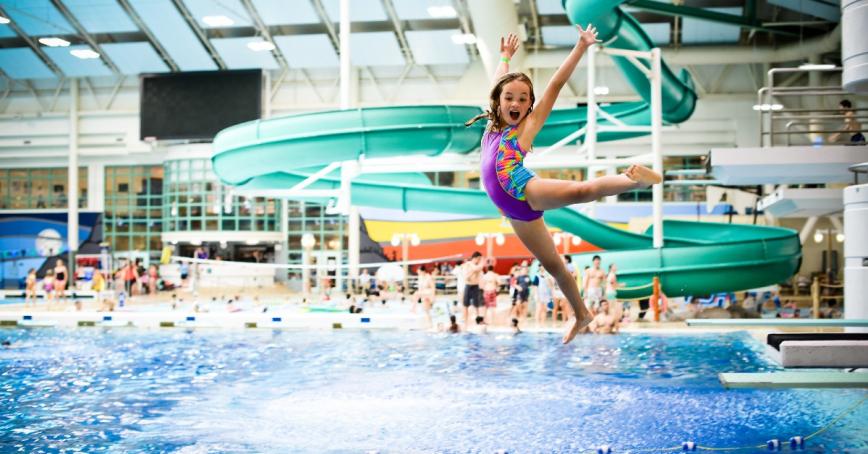 Young girl jumping into swimming pool. Photo credit: Saanich Parks & Recreation